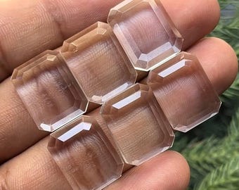 以下が含まれることがあります： 手の上に置かれた、透明でファセットカットされた長方形の宝石6個。おそらく水晶です。