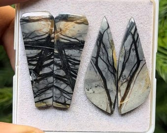 May include: Two pairs of polished gemstone cabochons. One pair is rectangular with a trapezoid top, the other is teardrop-shaped. Both pairs have a gray and cream base with black veining, resembling a tree branch pattern.