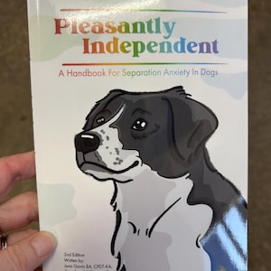 Puede incluir: Un libro titulado "Pleasantly Independent: A Handbook For Separation Anxiety In Dogs" con un perro de dibujos animados en blanco y negro en la portada. El libro es una segunda edición escrita por Jenn Gavin BA, CPDT-KA, fundadora de A Pleasant Dog e ilustrada por Kristine Hynes.