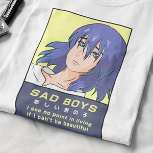 May include: White t-shirt with a graphic of a blue-haired anime character. The text "SAD BOYS 悲しい男の子 i see no point in living if i can't be beautiful" is printed on the shirt.