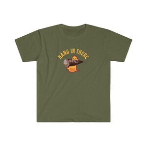 May include: A green t-shirt with a cartoon character holding a log and the text "Hang in there" in yellow.