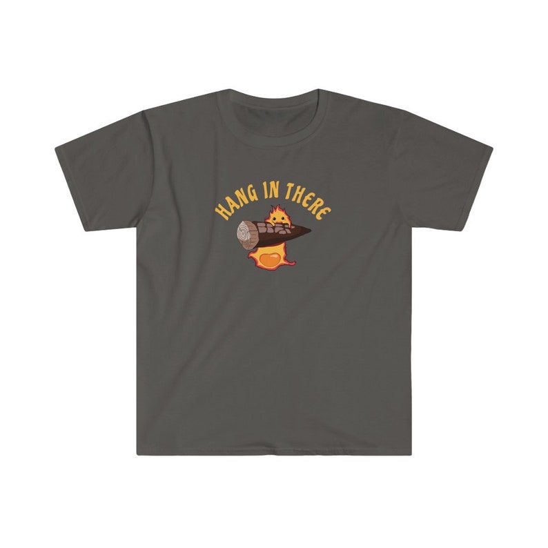 May include: A dark gray t-shirt with a cartoon character holding a log. The character is on fire and the text "HANG IN THERE" is written in a yellow circle around the character.