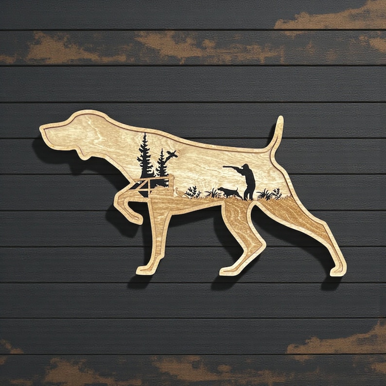 A three layered piece of wood art in the shape of a German Shorthaired Pointer on point.  It's a 3d design with the back layer having a hunter a GSP and flying pheasants engraved on it.