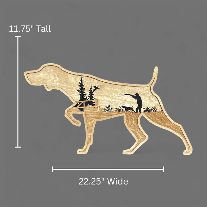 May include: Wooden dog silhouette with a hunting scene cut out. The dog is 11.75 inches tall and 22.25 inches wide. The cutout features a hunter, two dogs, trees, and a bird. The wood has a natural grain.