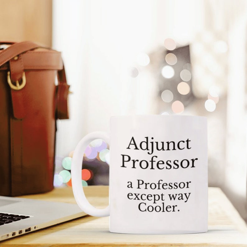 May include: White ceramic coffee mug with black text that reads "Adjunct Professor a Professor except way Cooler."