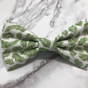 Op de afbeelding: Een witte strik met een groen varenbladpatroon.