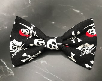 May include: Black bow tie with a white and red pirate skull and crossbones pattern.