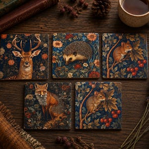 May include: A set of five square coasters featuring detailed illustrations of woodland animals including a deer, a hedgehog, a fox, and two mice, all set against a dark blue background filled with colourful flowers, leaves, and red berries.