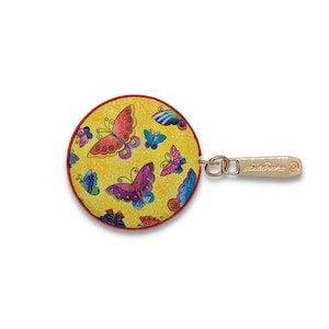 May include: A round, yellow coin purse with a red trim and a gold-colored zipper pull. The purse is decorated with colorful butterflies in shades of red, purple, blue, and green. The zipper pull has the text "Art Sugar" engraved on it.