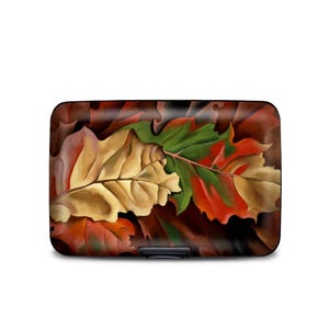 May include: A wallet with a colorful abstract painting of leaves in shades of red, green, brown, and yellow. The leaves are overlapping and appear to be falling.