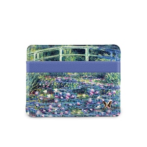 May include: A blue leather card holder with a printed image of a bridge over a pond with water lilies. The image is a painting in the style of Claude Monet.