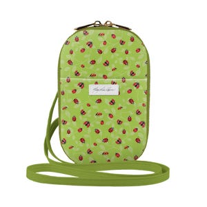 May include: A green crossbody bag with a ladybug print and a gold zipper. The bag has a long adjustable strap.