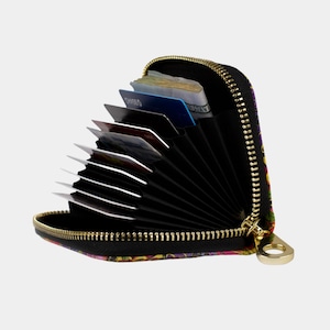 May include: A black zippered wallet with a colourful floral print. The wallet is open and has multiple card slots and a cash compartment.