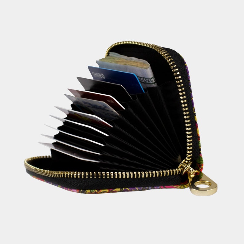 May include: A black zippered wallet with a colourful floral print. The wallet is open and has multiple card slots and a cash compartment.