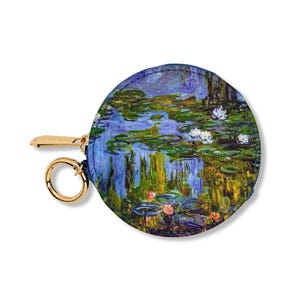 May include: Round coin purse with a zipper closure and a gold key ring. The purse features a printed image of a water lily pond with blue, green, and white water lilies.