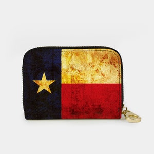 May include: A small zippered wallet with a distressed, vintage-style Texas flag design. The wallet is made of a textured material and has a gold zipper pull.