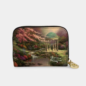 May include: A black zippered wallet with a colorful image of a garden scene with a gazebo, flowers, and a stream. The text "Thomas Kinkade" is printed on the wallet.