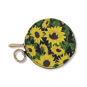 May include: A round black coin purse with a zipper closure and a gold key ring. The purse is decorated with a sunflower pattern.