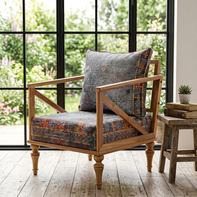 a wooden chair with a colorful patterned cushion, placed in front of a large window overlooking a garden.