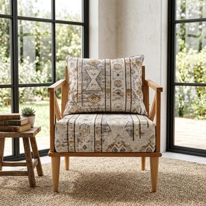 May include: Wooden armchair with a patterned cushion and seat. The cushion and seat fabric feature a geometric design in shades of gray, beige, and orange. The chair is set in front of a window with a view of greenery.
