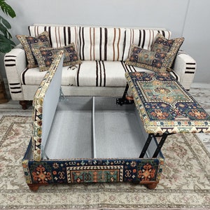 May include: A blue and orange patterned ottoman with a lift-top table. The ottoman has a storage compartment and is upholstered in a fabric with a traditional design.