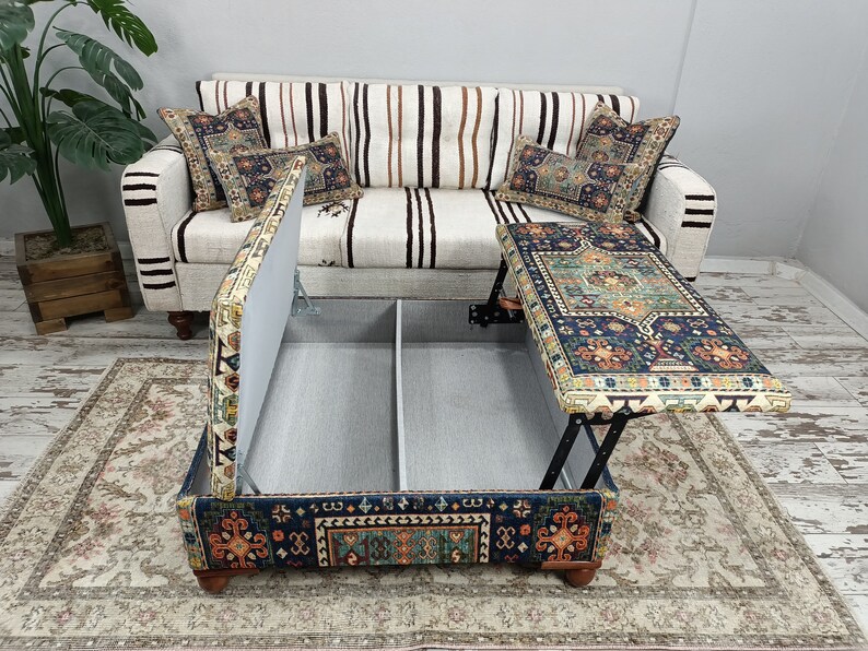 May include: A blue and orange patterned ottoman with a lift-top table. The ottoman has a storage compartment and is upholstered in a fabric with a traditional design.