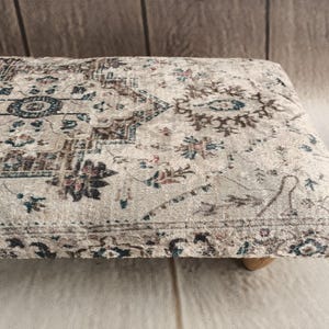 a decorative rug or cushion with a floral pattern on a wooden surface.