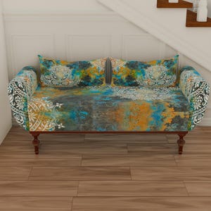 May include: A small, blue, yellow, and white patterned sofa with wooden legs. The sofa is in a room with white walls and wooden floors.