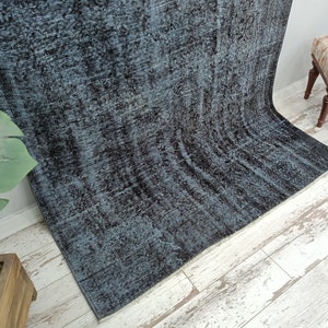 May include: A dark blue and black area rug with a distressed, vintage look. The rug has a subtle pattern and is made of a soft, plush material.