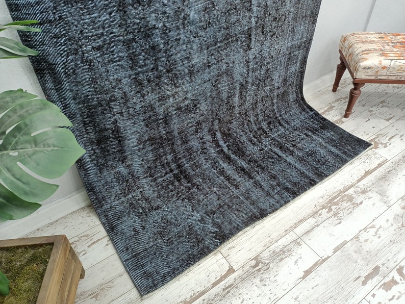 May include: A dark blue and black area rug with a distressed, vintage look. The rug has a subtle pattern and is made of a soft, plush material.