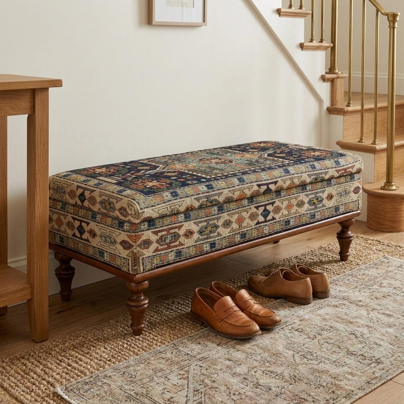 a wooden bench with a colorful, patterned cushion placed on a rug in a hallway. There are a pair of brown shoes and a pair of brown loafers placed on the rug next to the bench.