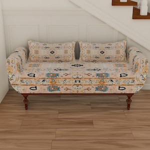 May include: A white and beige patterned loveseat with wooden legs. The loveseat has two pillows with a similar pattern.