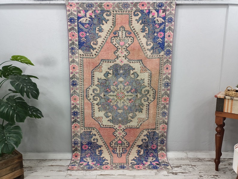 Pode incluir: Um tapete vintage rosa e azul com um padr&atilde;o floral. O tapete tem um aspeto desbotado e desgastado, perfeito para adicionar um toque de estilo bo&eacute;mio &agrave; sua casa.
