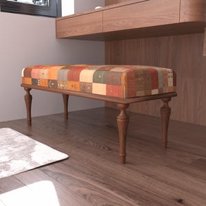 a wooden bench with a colorful, patchwork-style cushion on a hardwood floor.
