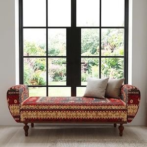 May include: A patterned bench in red, beige, and grey, with curved armrests and wooden legs. Two neutral cushions sit on the bench, which is placed in front of a large window. The bench is approximately 150 cm long.