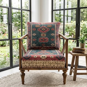 Könnte beinhalten: Holzsessel mit gemustertem Kissen und Sitzfläche in den Farbtönen Teal, Rot und Beige. Der Stuhl hat ein klassisches Design mit Lattenrücken und Armlehnen. Der Stuhl steht auf einem neutralfarbenen Teppich.