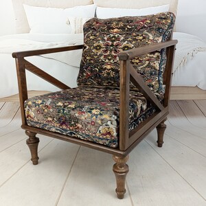 May include: A dark brown wooden armchair with a patterned fabric seat and back. The chair has a unique X-shaped design on the back and legs.