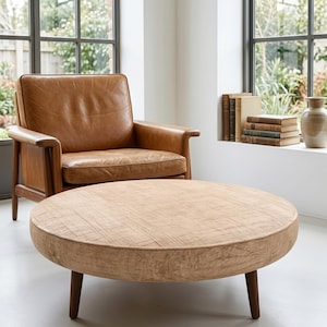 Mesa de centro redonda de color beige con textura sólida / Otomana minimalista para sala de estar