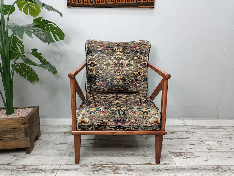 May include: A wooden armchair with a patterned fabric upholstery. The chair has a dark wood frame and a geometric pattern on the fabric.