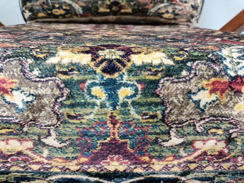 May include: Close-up of a chair with a patterned fabric upholstery. The fabric features a colorful design with shades of green, blue, red, and beige.