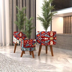 May include: Three cylindrical plant stands with wooden legs, each featuring a vibrant red, blue, and white patterned fabric cover. The stands hold green potted plants of varying heights, creating a tiered display of decorative home accents.