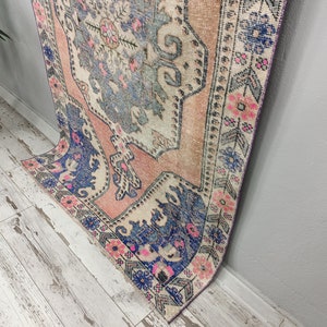 Pode incluir: Um tapete vintage com um padr&atilde;o floral desbotado em rosa, azul e branco. O tapete tem um visual desgastado e &eacute; perfeito para adicionar um toque de estilo bo&ecirc;mio a qualquer c&ocirc;modo.