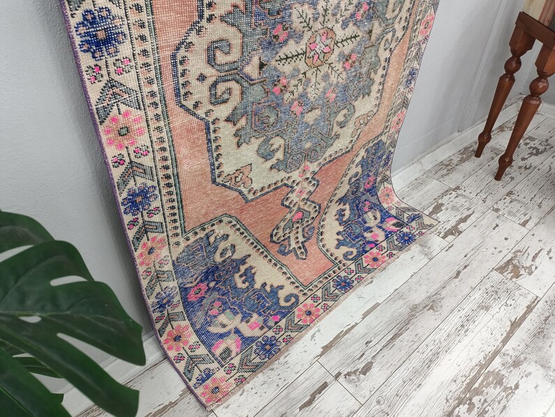 Pode incluir: Um tapete vintage rosa e azul com um padr&atilde;o floral. O tapete tem um aspeto desbotado e desgastado, perfeito para adicionar um toque de estilo bo&eacute;mio &agrave; sua casa.