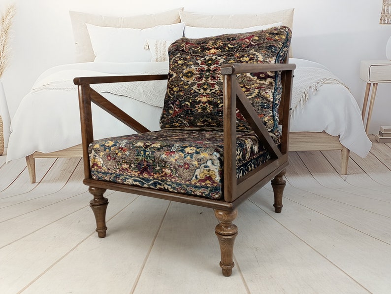 May include: A dark brown wooden armchair with a patterned fabric seat and back. The chair has a unique X-shaped design on the back and turned legs.