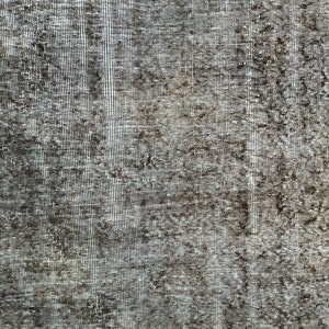 May include: Close-up of a textured, woven fabric with a gray and brown color scheme. The fabric has a subtle pattern and a slightly rough texture.
