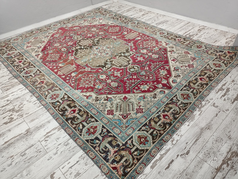 May include: A vintage rug with a red, blue, and cream color scheme. The rug has a central medallion with intricate floral patterns and a border with geometric designs.