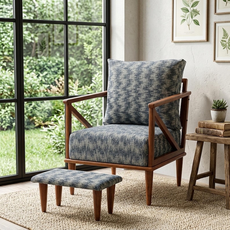 a cozy living room with a wooden chair and a matching ottoman, positioned near a large window that offers a view of a lush garden. The chair has a blue and gray patterned cushion, and the ottoman is a matching shade of blue. The room is decorated with a few potted plants and framed pictures on the wall, creating a warm and inviting atmosphere.