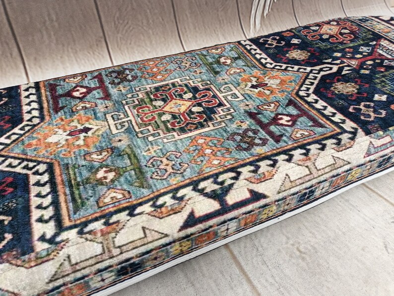 Pu&ograve; includere: Un tappeto rettangolare blu, bianco, rosso e arancione con un bordo bianco. Il tappeto ha un design tradizionale con dettagli intricati.