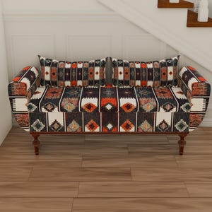 May include: A black, red, and white patterned loveseat with wooden legs. The loveseat is upholstered in a geometric pattern.