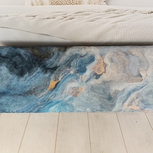 Puede incluir: Un coj&iacute;n de tiro azul y gris con un patr&oacute;n abstracto y un sutil brillo dorado.